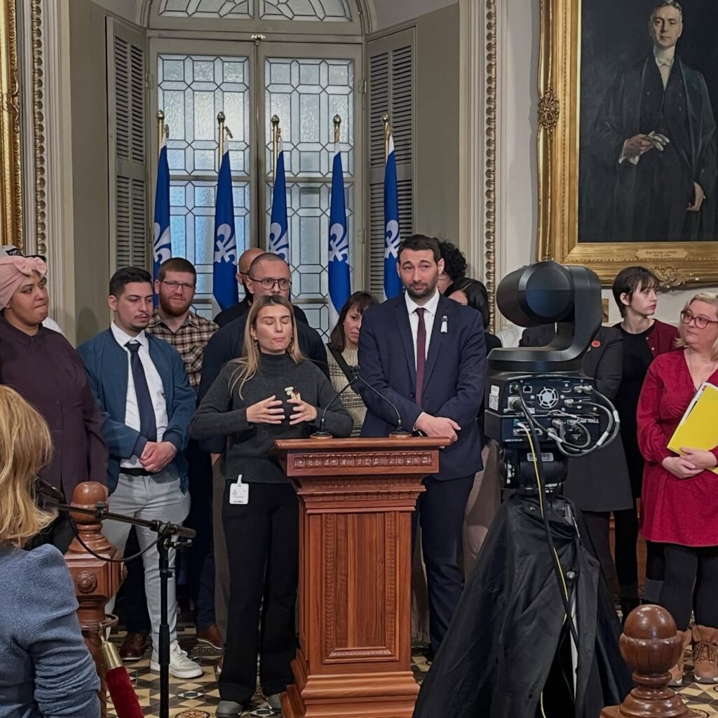 Des membres de la communauté immigrante soutenus par le député Guillaume Cliche-Rivard devant l’Assemblée nationale du Québec, le 26 novembre 2025 (source : Le Québec c’est nous aussi)